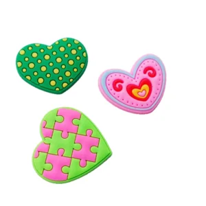 Green and pink heart and puzzle piece embroidered patch designs on a white background.