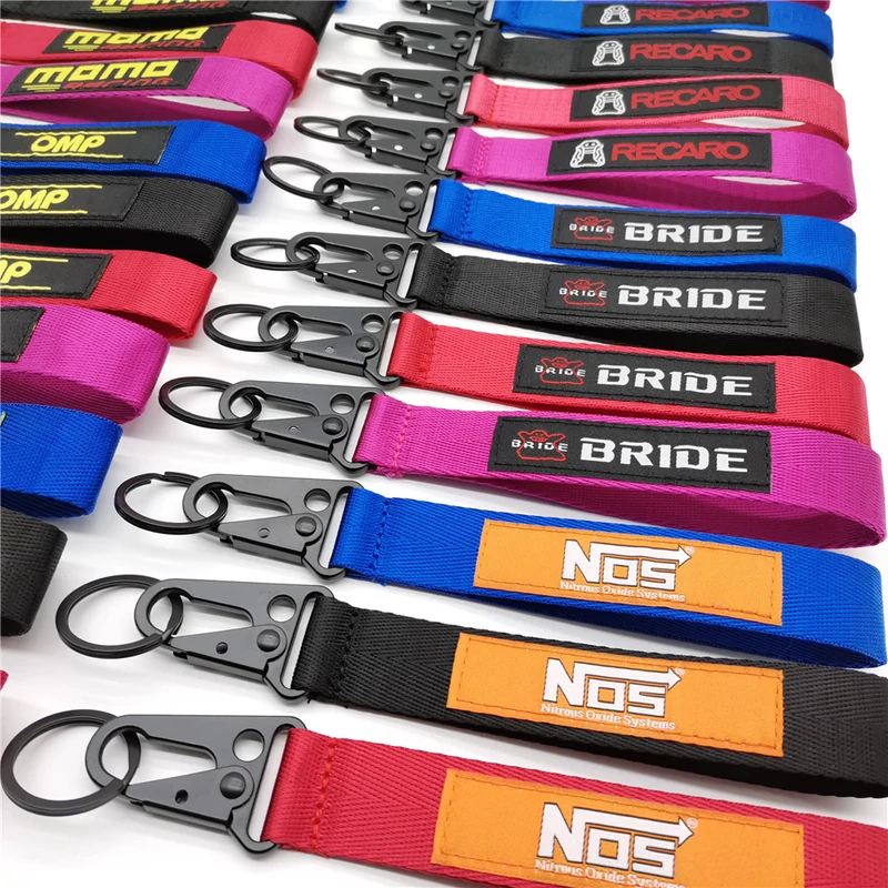 Rows of colorful automotive branded short fabric straps with metal snap hooks.