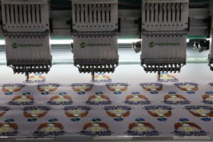 Close-up of the needle and thread on a multi-head embroidery machine stitching a custom embroidered patch