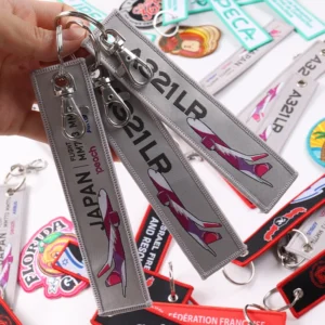 Three gray A321LR Japan flight key tags with airplane graphic and swivel clasps