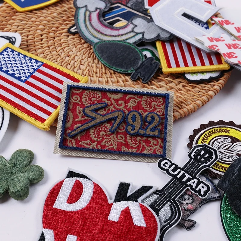 Mixed embroidered patches including an American flag, race number and guitar on a woven mat