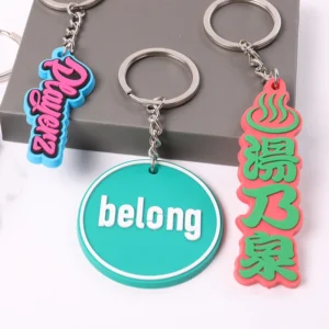 Three PVC keychains with colorful lettering and green belong logo