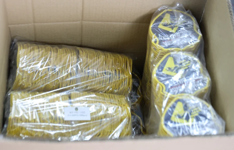 Carton containing bundled yellow edged and blue emblem patches