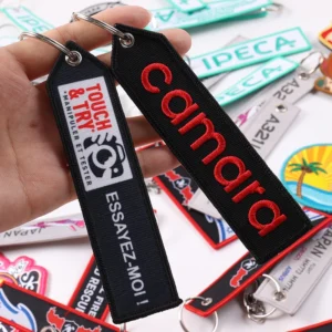 Black fabric key tags with red Calmara embroidery and Touch and Try graphic