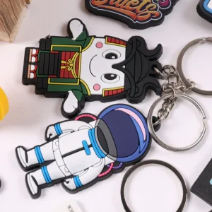 Cartoon figure and white astronaut soft PVC keychains with metal rings on white.