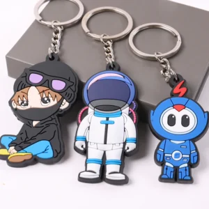 Three character PVC keychains including a white astronaut and blue robot