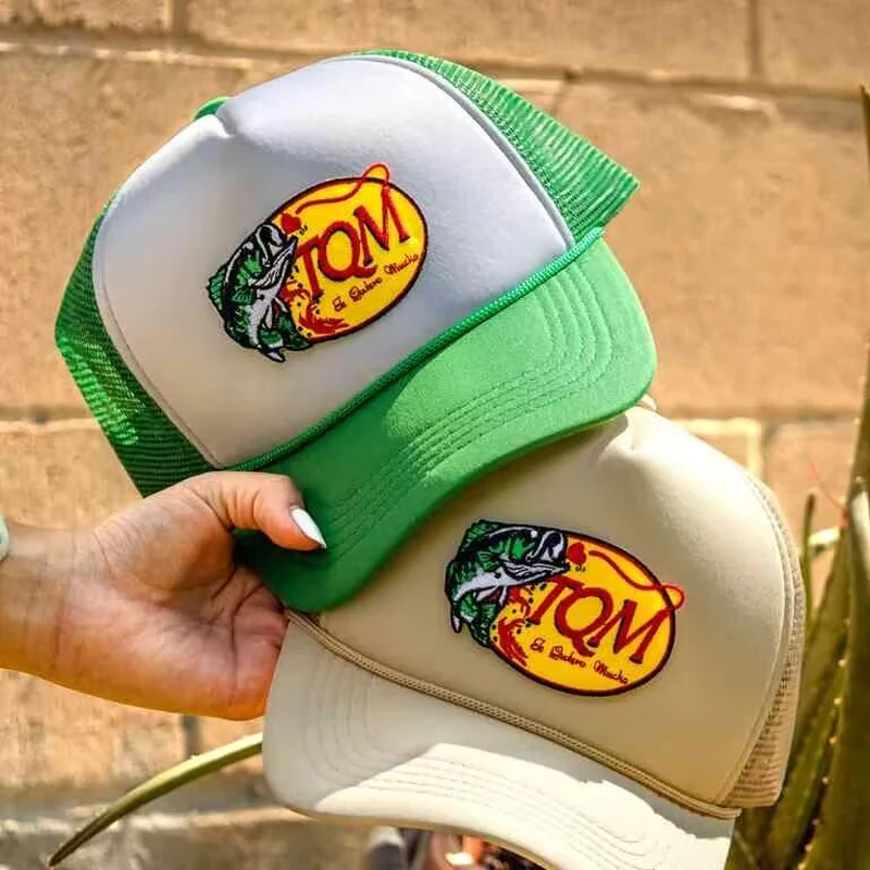 Green and beige trucker caps with colorful comic style patches on the front.