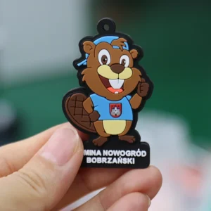 Custom brown beaver mascot PVC rubber tag with blue shirt and raised lettering