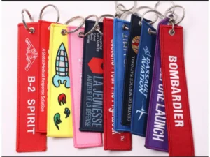 Colorful custom embroidered flight tag keychains with printed lettering and silver metal rings