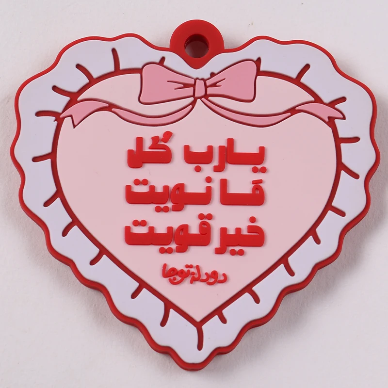 Pink and white heart-shaped PVC tag with bow and raised red script