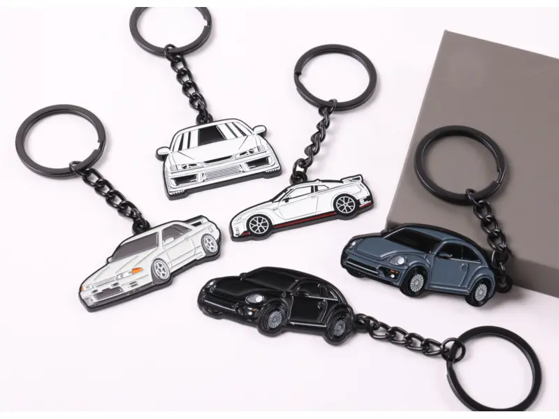 Collection of custom silver and black metal car-shaped keychains with chain and ring hardware