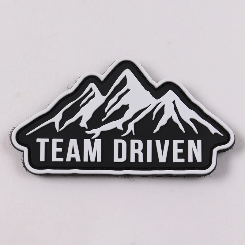Black and white mountain-shaped PVC patch with Team Driven text