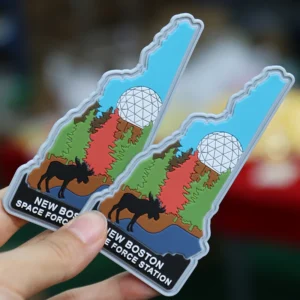 Two custom PVC patches shaped like New Hampshire with forest and dome artwork