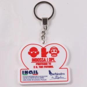 White heart-shaped safety campaign PVC keychain with red protective equipment icons