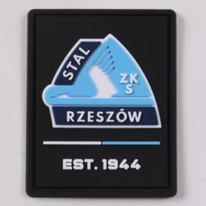 Black rectangular PVC patch with blue sailboat logo and white Rzeszow lettering
