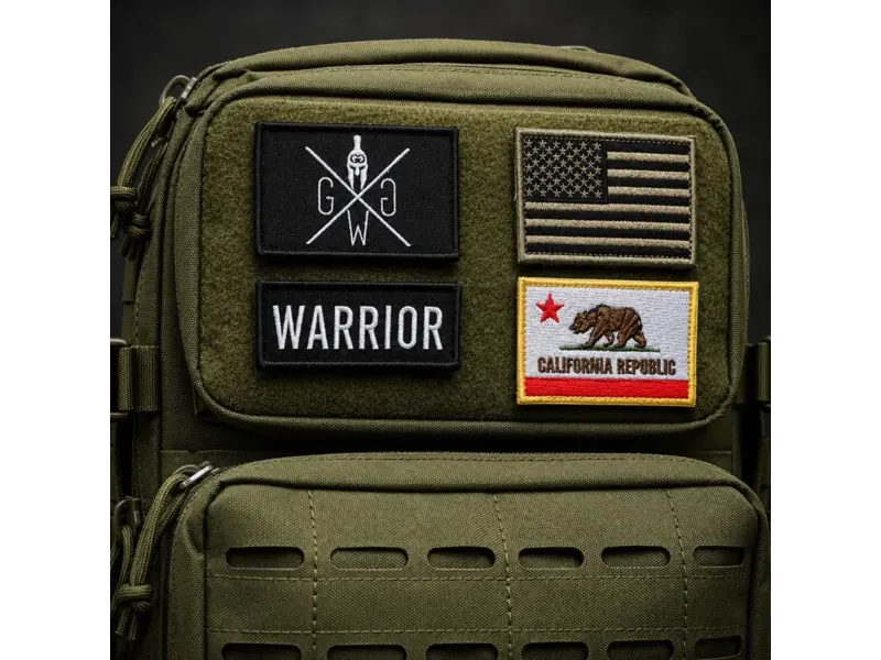 Black tactical patches and flag-style badges attached to an olive green tactical backpack