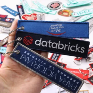 Three navy blue branded fabric keychains held together