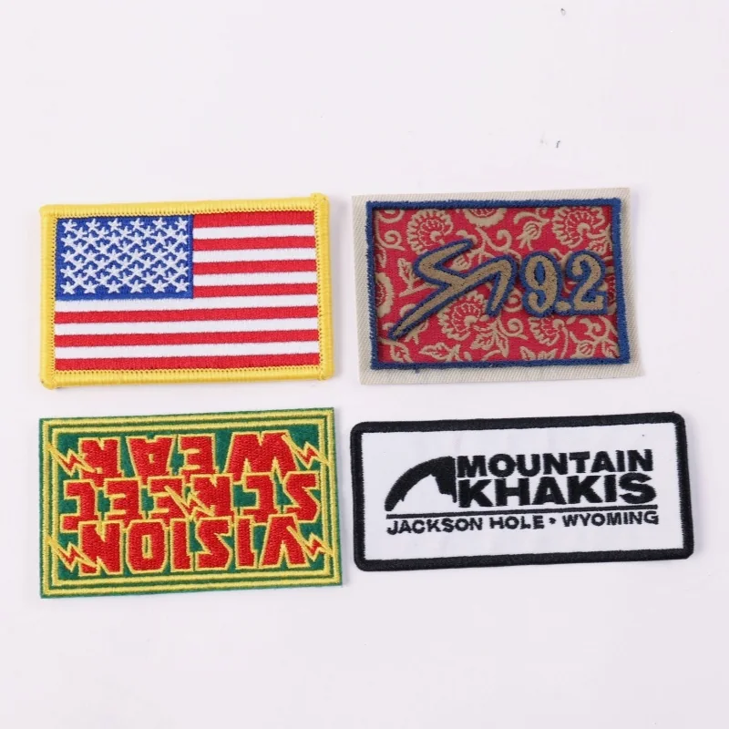 Four rectangular patches showing an American flag, race design, streetwear logo and mountain text