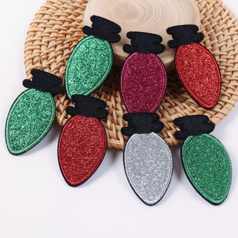 Red green and silver glitter Christmas light bulb shaped appliqués on a woven mat