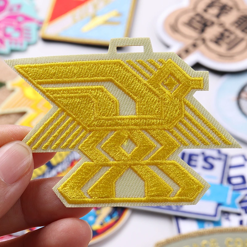 Metallic gold wing insignia embroidered patch with geometric center emblem