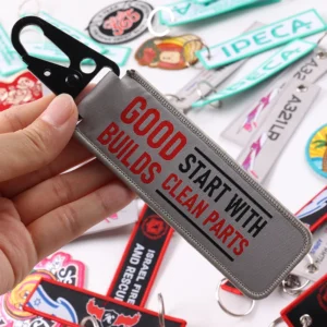 Gray fabric key tag with Good Builds Start With Clean Parts text and black clip