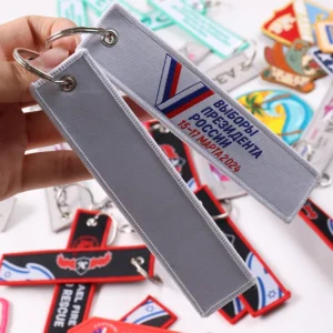 Two gray fabric key tags, one with Russian text and tricolor graphic