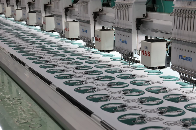 Rows of green oval emblems stitched by multiple embroidery heads