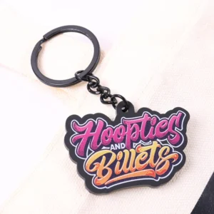 Black soft PVC keychain with colorful Hoopties and Buies lettering on a metal ring.