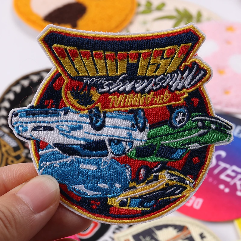 Colorful racing car and logo themed embroidered patch held in hand