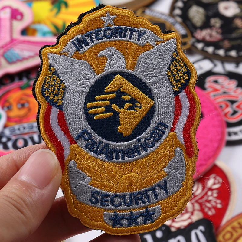 Gold and gray Interstate Security Police embroidered eagle badge patch held in hand