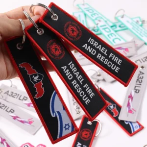 Three black fabric key tags with Israel Fire and Rescue text and red trim