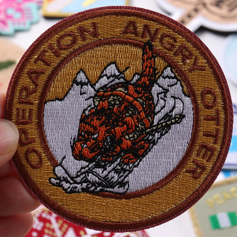 Brown round Operation Angry Otter embroidered patch with detailed orange otter artwork