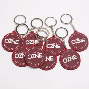 Group of maroon OZNE circular PVC keychains with silver rings