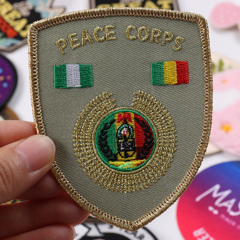 Beige shield Peace Corps embroidered patch with Nigeria and Ireland flags