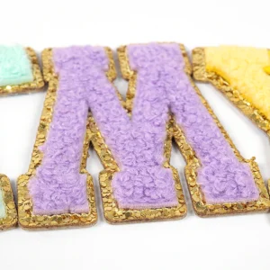 Purple varsity letter M chenille patch with metallic gold embroidered border