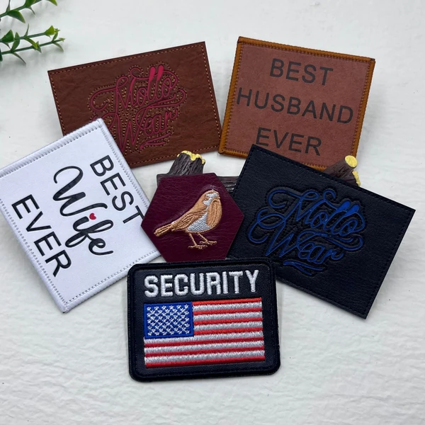 Assorted patches on white fabric, including BEST WIFE EVER, BEST HUSBAND EVER, a bird and a SECURITY American flag design.