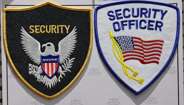 Two shield-shaped patches: a black SECURITY patch with an eagle and a white SECURITY OFFICER patch with an American flag.