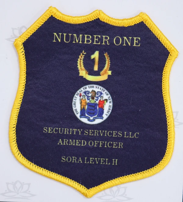 Navy shield patch with yellow NUMBER ONE lettering, a number 1, a central crest and SECURITY SERVICES LLC ARMED OFFICER text.