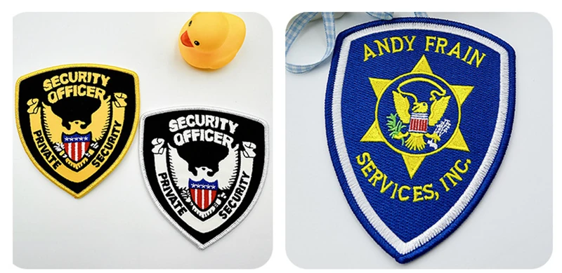 Two black SECURITY OFFICER shield patches with yellow or white embroidery beside a blue ANDY FRAIN SERVICES shield badge.